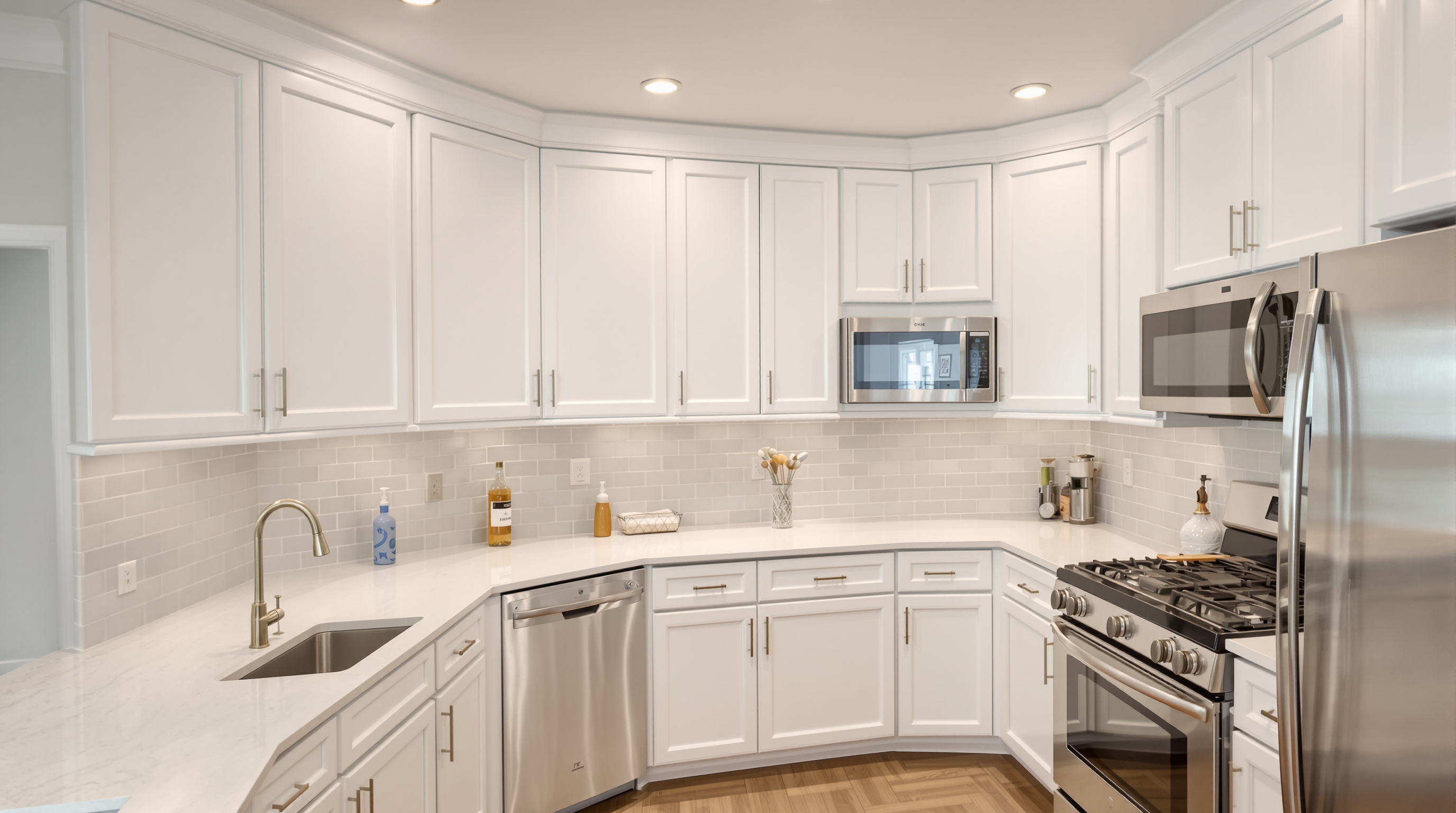 Transitional white kitchen with oversized island and pendant lights